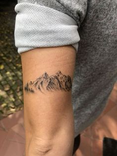 a person with a mountain tattoo on their arm