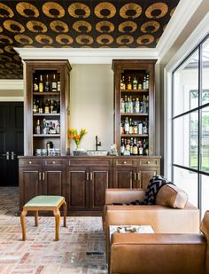 a living room filled with furniture next to a bar