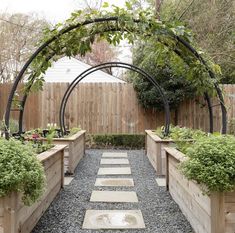 an outdoor garden area with wooden planters and gravel path leading up to the entrance