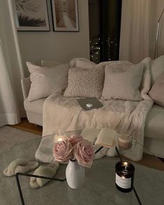 a living room with a couch, coffee table and candles on the floor in front of it