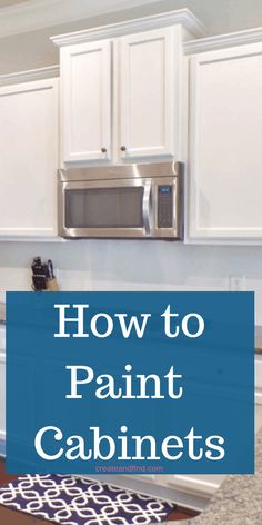 a kitchen with white cabinets and silver microwave