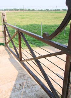 an iron gate in the middle of a grassy field