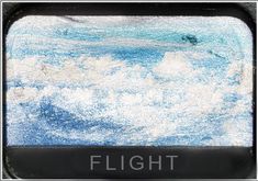 an airplane window with the word flight written on it in front of some white clouds