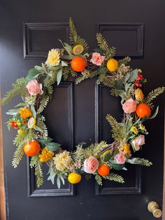 an orange and flower wreath hangs on the front door