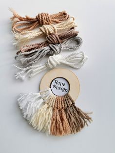 three tassels with rope hanging from the top and one in the middle on a white surface