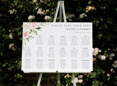 a seating chart on a easel in front of some pink and white flowers with the words please take your seat poppy's tommy