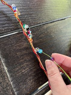 a person is holding some string with beads on it