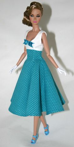 a doll wearing a blue and white dress with polka dots on it's skirt