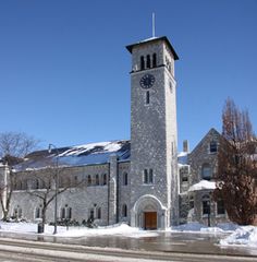 an old building with a clock tower in the snow