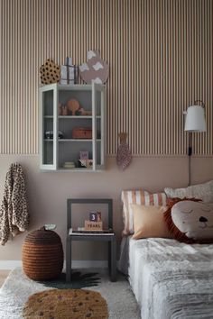 a room with a bed, table and shelves on the wall next to each other