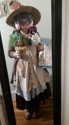 a woman is taking a selfie in the mirror wearing a hat and holding a basket