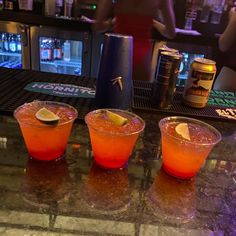 three drinks are sitting on the bar top