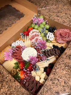 a box filled with assorted cheeses and meats on top of a counter