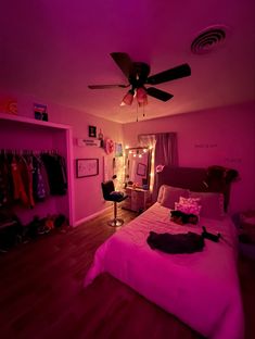 a bed room with a neatly made bed and purple lights on the ceiling above it