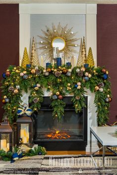 Fireplace decorated for Christmas with garland, mirror, lanterns and glass tabletop trees with navy blue accent. Orange And Navy Christmas, Dark Blue And Green Christmas Decor, Copper Christmas Fireplace, Blue Copper Christmas Decor, Navy And Orange Christmas Decor, Blue Copper And Gold Christmas Tree, Navy Gold Brown Christmas Tree, Blue And Bronze Christmas Decor, Navy And Copper Christmas Tree