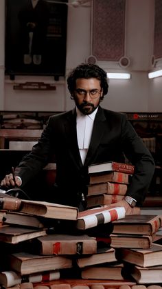 a man in a tuxedo standing behind stacks of books with the caption jai bhim latest stills