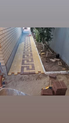 a man is working on a walkway made out of bricks