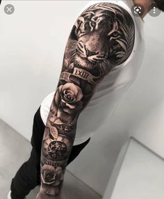 a man's arm with a tiger and roses tattoo on the left sleeve,