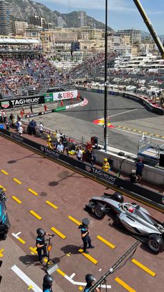 an aerial view of a race track with cars and people in the stands watching it