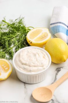 lemons, dill, and other ingredients on a marble surface