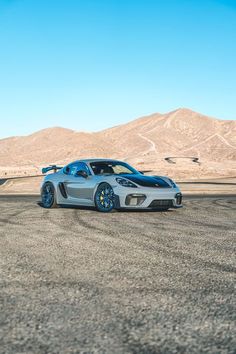 a silver sports car parked in the desert