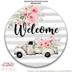 a welcome sign with an old truck and flowers on the front, in black and white stripes