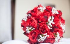 a bridal bouquet with red roses and baby's breath