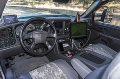 the interior of a vehicle with an electronic display on the dash board and steering wheel