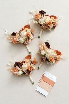 three bridal bouquets with flowers and feathers on them are arranged next to each other