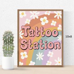 a poster with the words tattoo station on it next to a cactus and potted plant