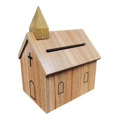 a wooden toy house with a cross on the roof and two windows, made to look like a church