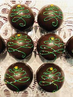 six chocolate balls decorated with green and yellow stringing