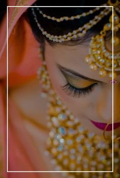 a woman in a bridal outfit with jewelry on her head and eyes closed to the side