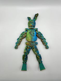 a blue and green plastic toy with an animal figure on it's back legs