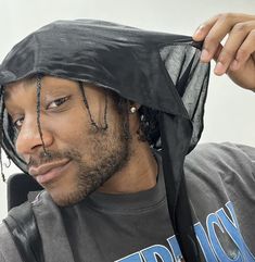 a man with dreadlocks wearing a black hat