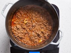 a pot filled with food sitting on top of a stove next to a digital scale