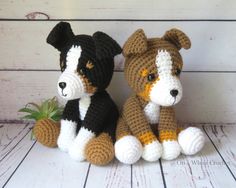 two crocheted dogs sitting next to each other on a white wooden floor with a plant