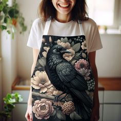 a woman wearing an apron with a black bird on it