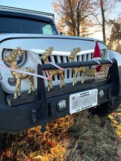 a jeep decorated for christmas with gold reindeer decorations on the front bumper and tailgate