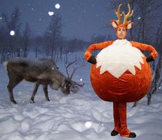 a man dressed as a reindeer standing in the snow