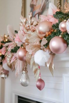 a fireplace mantel decorated with pink, gold and white christmas decorations on top of it