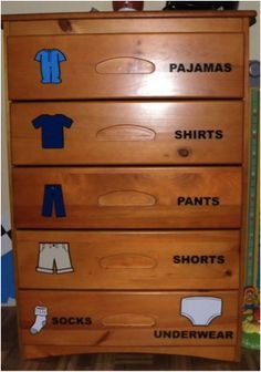 a wooden dresser with clothes on it and the words pajamas, pants, shorts, t - shirts