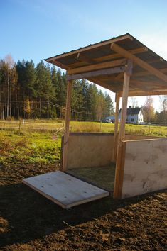 a small wooden structure in the middle of a field