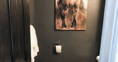 a bathroom with a sink, toilet and painting on the wall