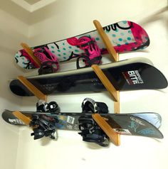 three snowboards are mounted to the wall and one is upside down with skis on it