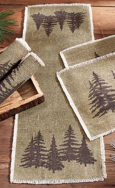 placemats and coasters with trees on them sitting on a wooden table top