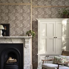 a living room filled with furniture and a fire place in front of a white cabinet