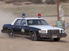 a police car driving down a dirt road