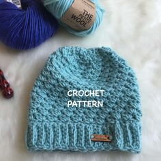 a crochet hat with the word crochet written on it next to two skeins of yarn