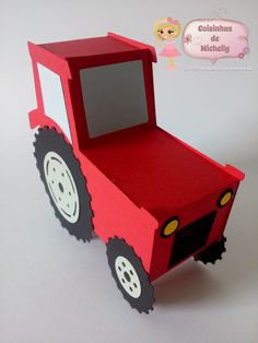 a red truck shaped box with wheels on the front and sides, cut out to look like a car